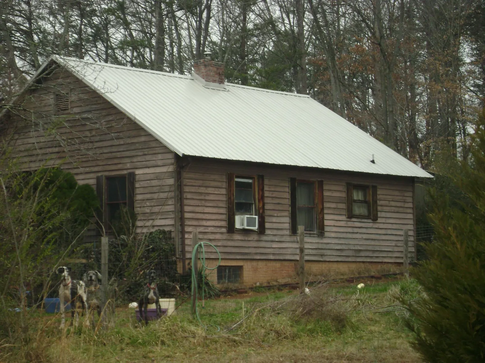 White metal roof on an old wood sided farmhouse, from a Metal Roof Installation job in Old Fort